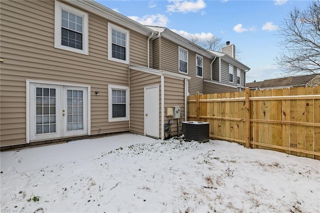 snow covered property featuring french doors and central air condition unit