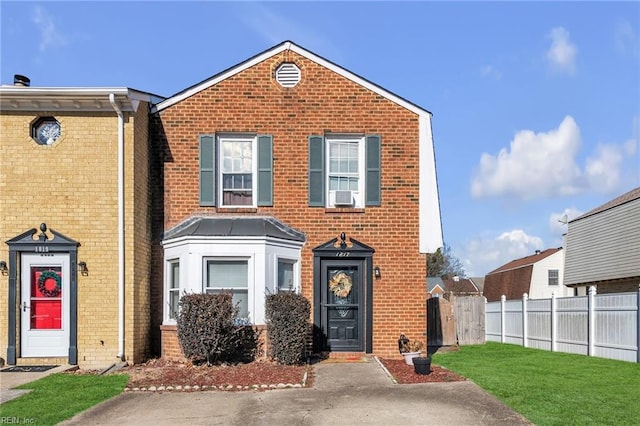 view of front of property featuring a front yard and cooling unit