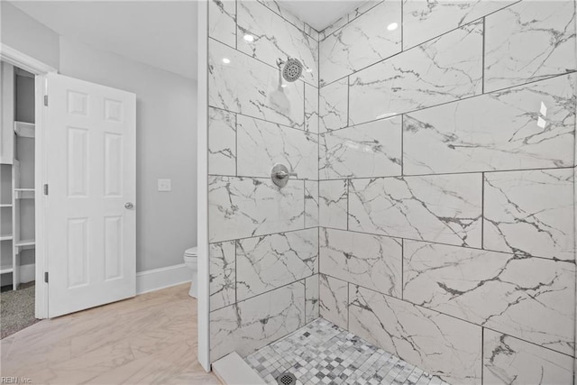 bathroom with toilet and tiled shower