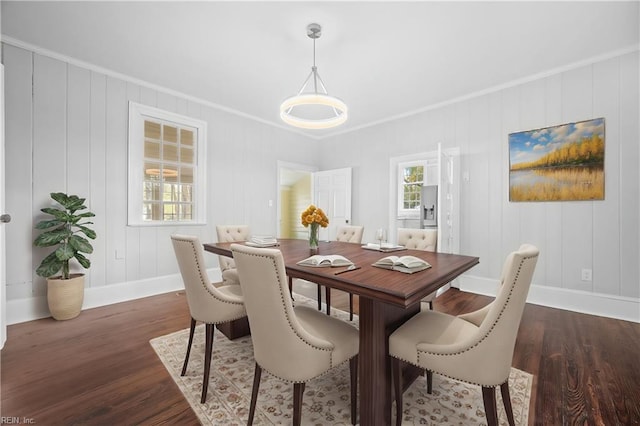 dining space with dark wood-type flooring and ornamental molding