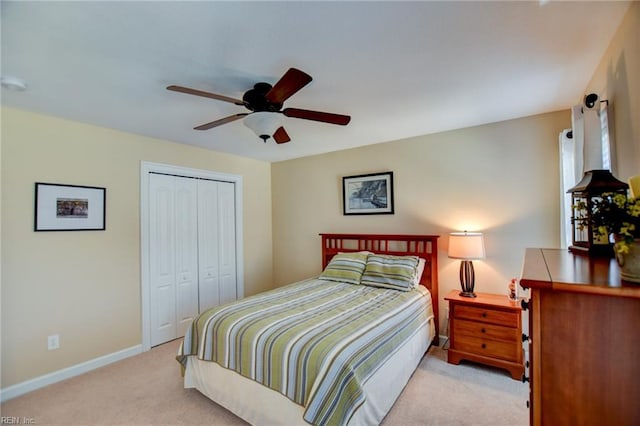 carpeted bedroom with ceiling fan and a closet