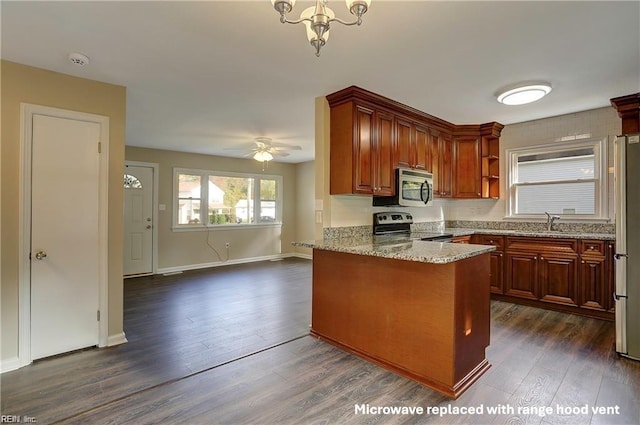 kitchen featuring light stone countertops, appliances with stainless steel finishes, sink, kitchen peninsula, and dark hardwood / wood-style floors