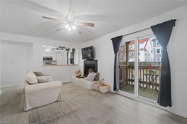 living room with ceiling fan and light hardwood / wood-style flooring