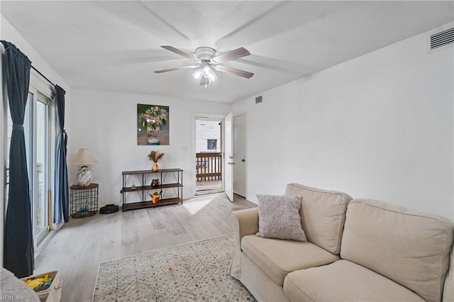 living room with light wood-type flooring and ceiling fan