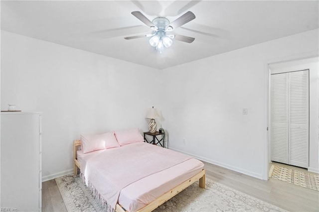 bedroom with light hardwood / wood-style flooring, a closet, and ceiling fan