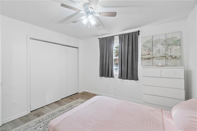 bedroom with light hardwood / wood-style flooring, a closet, and ceiling fan