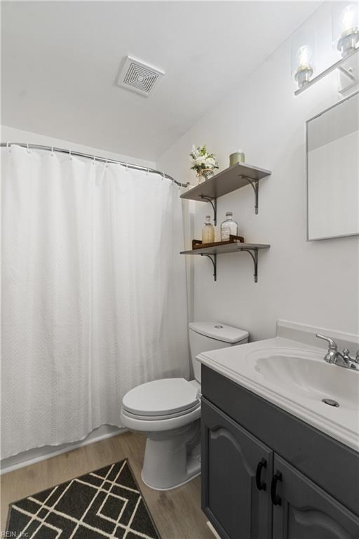 bathroom featuring vanity, toilet, and hardwood / wood-style floors