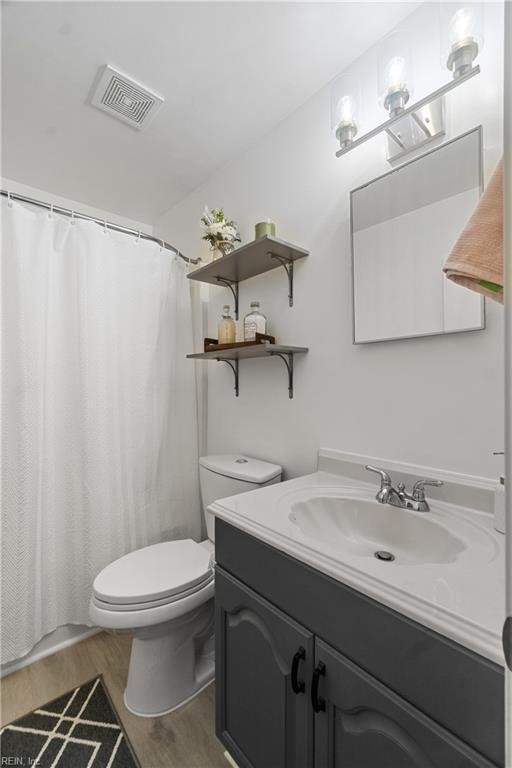 bathroom with hardwood / wood-style flooring, toilet, and vanity