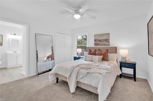 carpeted bedroom with ceiling fan, ensuite bathroom, and a closet