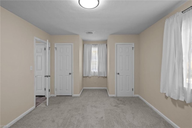 unfurnished bedroom featuring light carpet