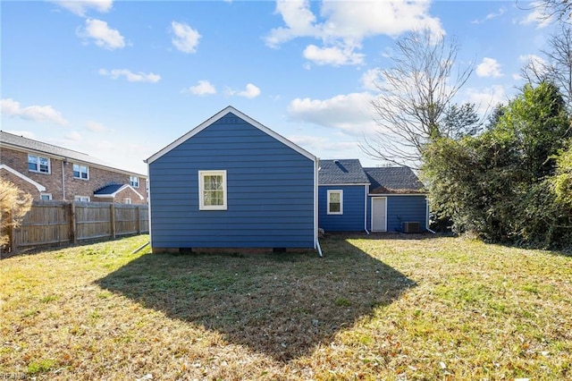 rear view of property featuring a yard and central AC unit