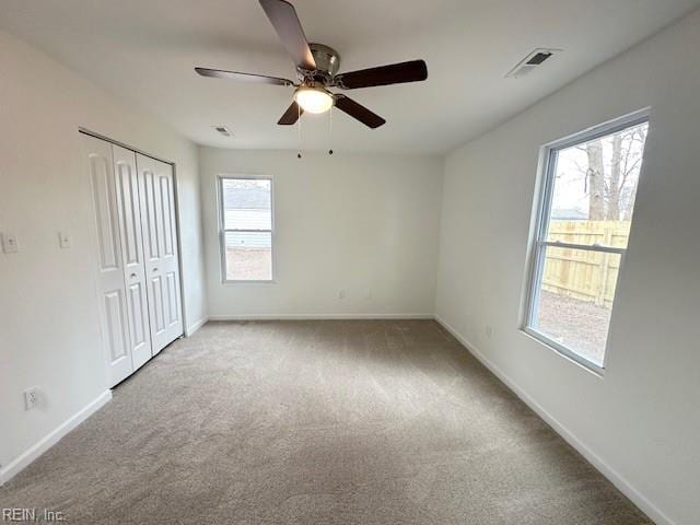 spare room with ceiling fan and light colored carpet