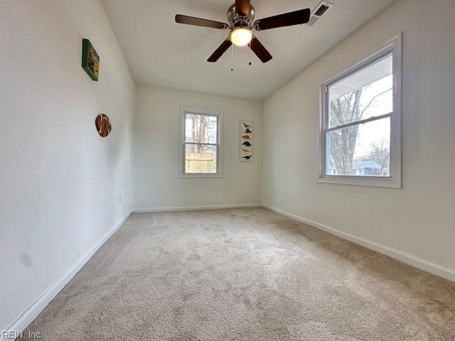 carpeted spare room with ceiling fan and a healthy amount of sunlight