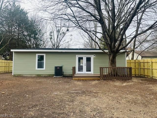 rear view of property featuring a deck, french doors, and central air condition unit