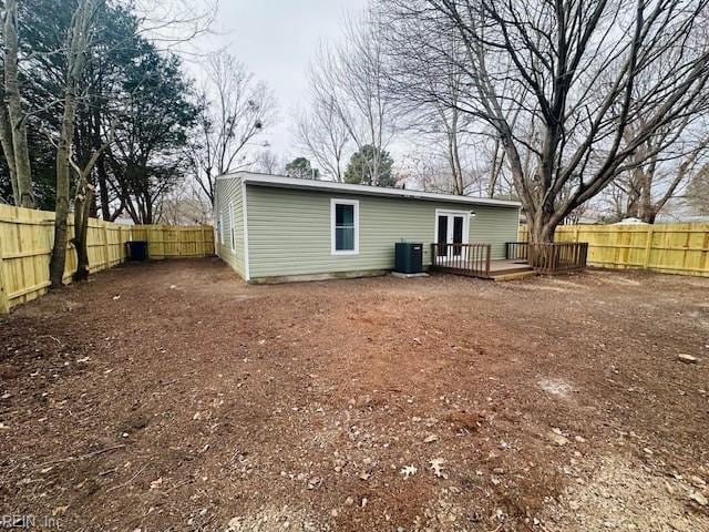 back of property with central AC, a deck, and french doors