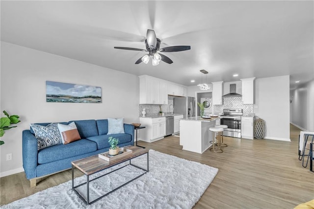 living room with hardwood / wood-style floors, washer / dryer, and ceiling fan