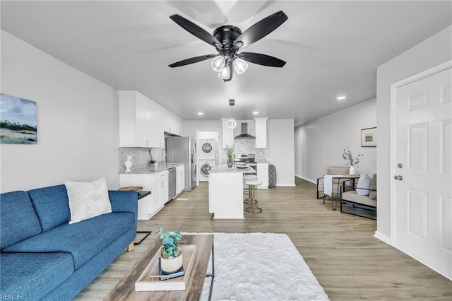 living room with ceiling fan and light hardwood / wood-style flooring