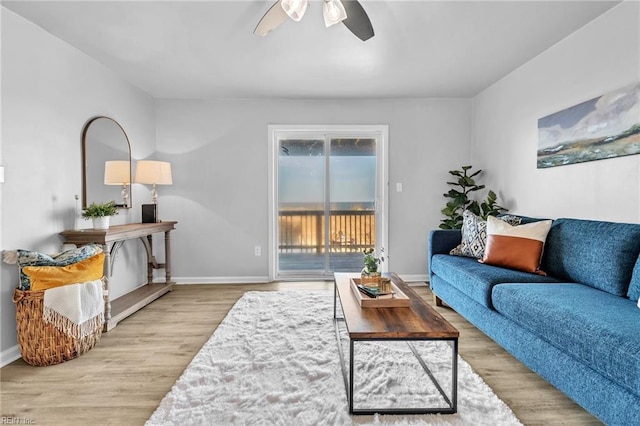 living room with light hardwood / wood-style floors and ceiling fan