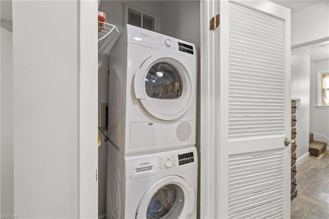 washroom featuring stacked washer and clothes dryer and light hardwood / wood-style flooring