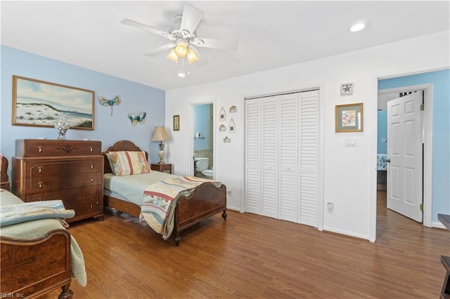 bedroom featuring ceiling fan, hardwood / wood-style floors, a closet, and ensuite bath