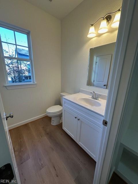 bathroom featuring vanity, hardwood / wood-style flooring, and toilet