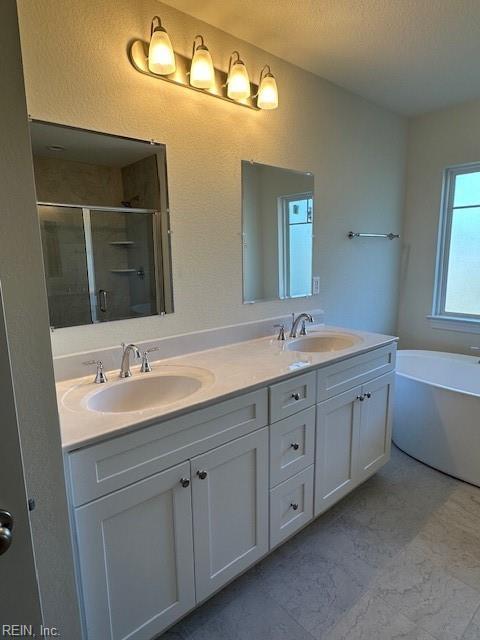 bathroom featuring vanity, a textured ceiling, and separate shower and tub