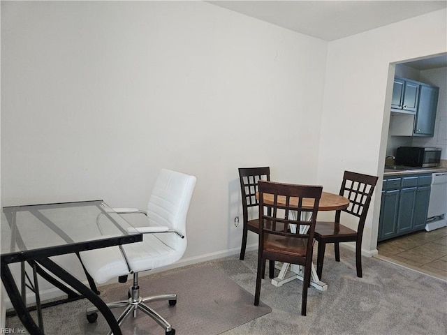 dining space with sink and light colored carpet