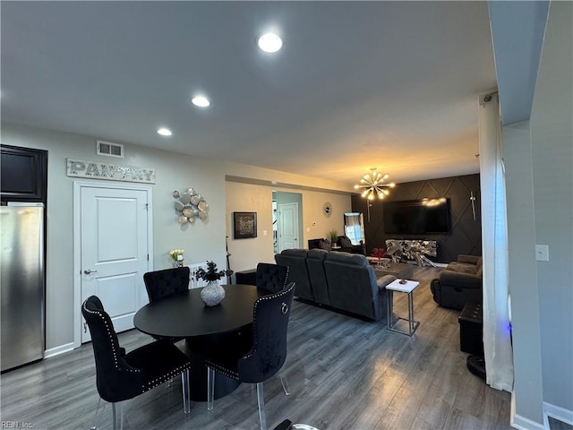 dining space with hardwood / wood-style flooring and an inviting chandelier