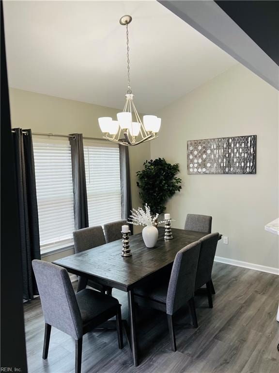 dining space with vaulted ceiling, a chandelier, and dark wood-type flooring