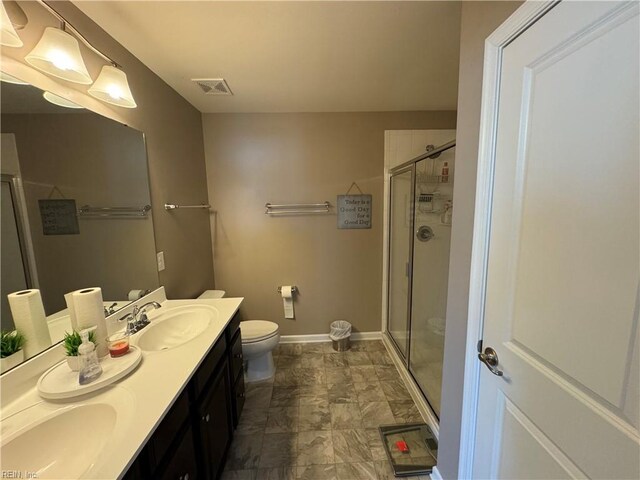 bathroom featuring vanity, toilet, and an enclosed shower