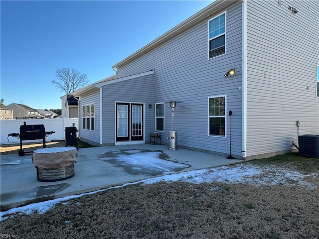 rear view of house featuring a fire pit, a patio area, and cooling unit