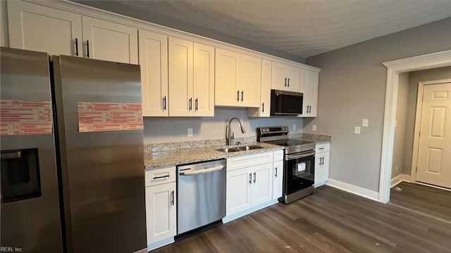 kitchen with sink, stainless steel appliances, white cabinets, and light stone countertops