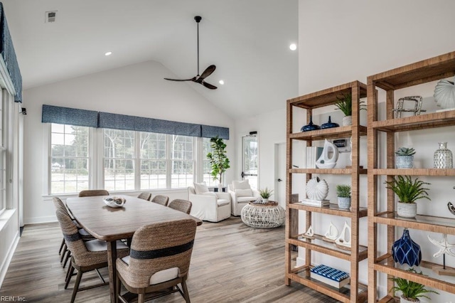 dining room featuring hardwood / wood-style floors, high vaulted ceiling, and ceiling fan