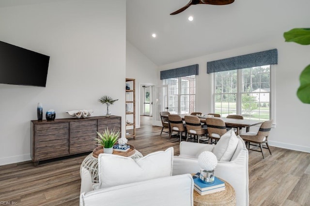 living room with ceiling fan, hardwood / wood-style floors, and high vaulted ceiling