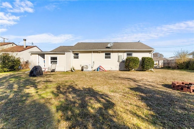 back of house with a yard and a fire pit