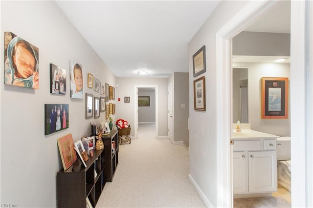 hallway featuring light carpet and sink