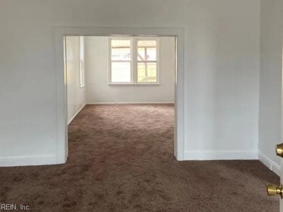 unfurnished room with dark colored carpet