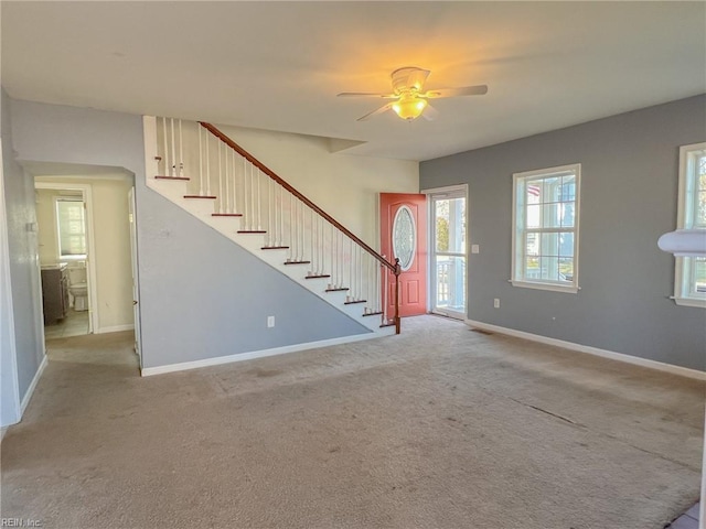 unfurnished living room featuring light carpet and ceiling fan