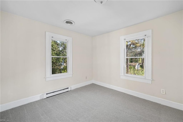 spare room featuring a baseboard radiator, a healthy amount of sunlight, and carpet flooring