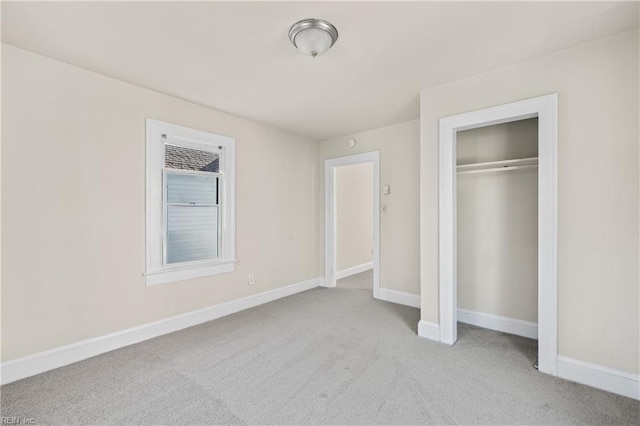 unfurnished bedroom featuring light carpet and a closet