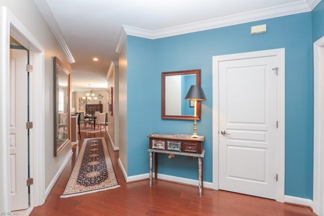 corridor featuring ornamental molding, an inviting chandelier, and wood-type flooring