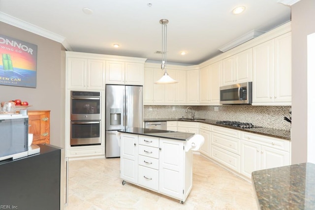 kitchen featuring appliances with stainless steel finishes, white cabinetry, sink, decorative light fixtures, and backsplash