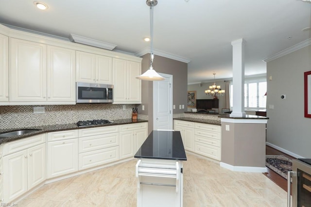 kitchen featuring a center island, decorative light fixtures, ornamental molding, backsplash, and stainless steel appliances