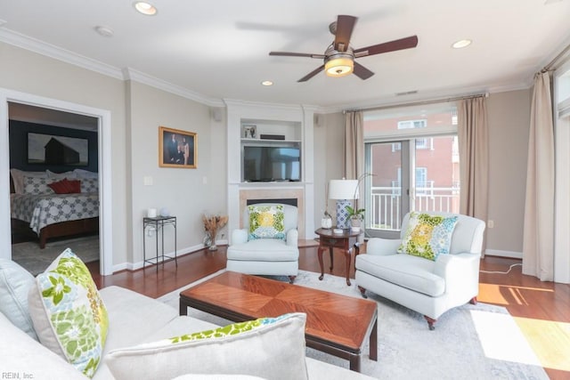 living room featuring ceiling fan, dark wood-type flooring, built in features, and ornamental molding