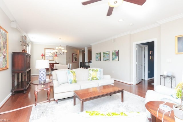 living room with ceiling fan with notable chandelier, dark wood-type flooring, and ornamental molding