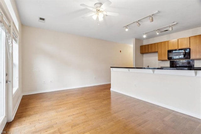 kitchen featuring ceiling fan and light hardwood / wood-style flooring