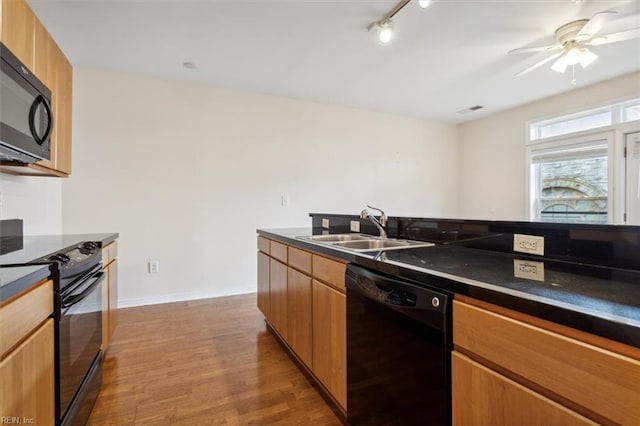 kitchen with ceiling fan, sink, hardwood / wood-style flooring, rail lighting, and black appliances