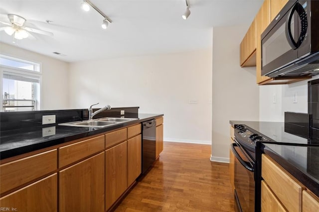 kitchen with sink, black appliances, ceiling fan, and wood-type flooring