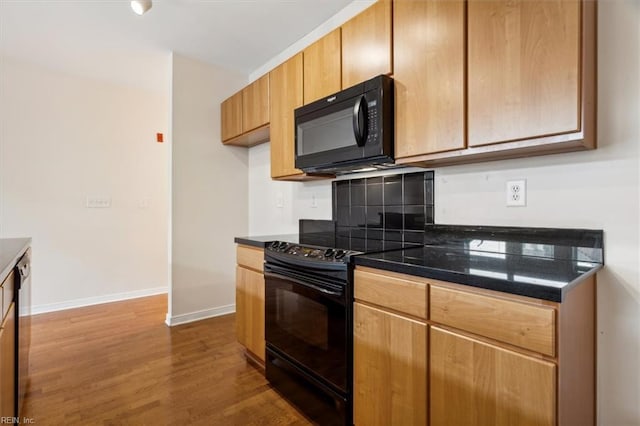 kitchen with black appliances and dark wood-type flooring