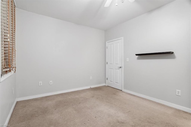 empty room featuring ceiling fan and light colored carpet